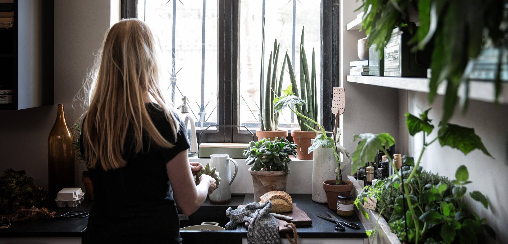 Woman cooking in SieMatic kitchen with herb garden