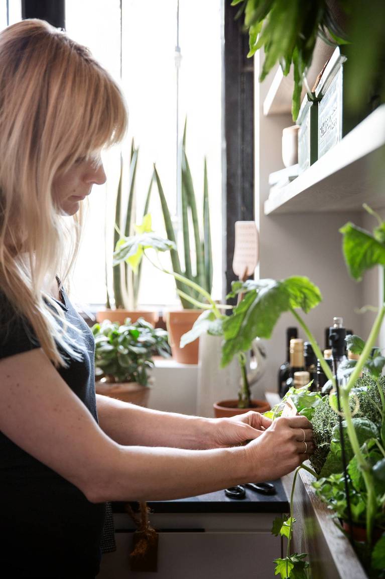 Woman picking fresh herbs from garden in SieMatic kitchen