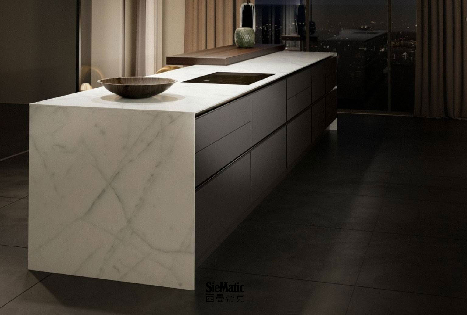 Minimalist kitchen design with handleless island, with SieMatic StoneDesign countertop and side panels in bright marble